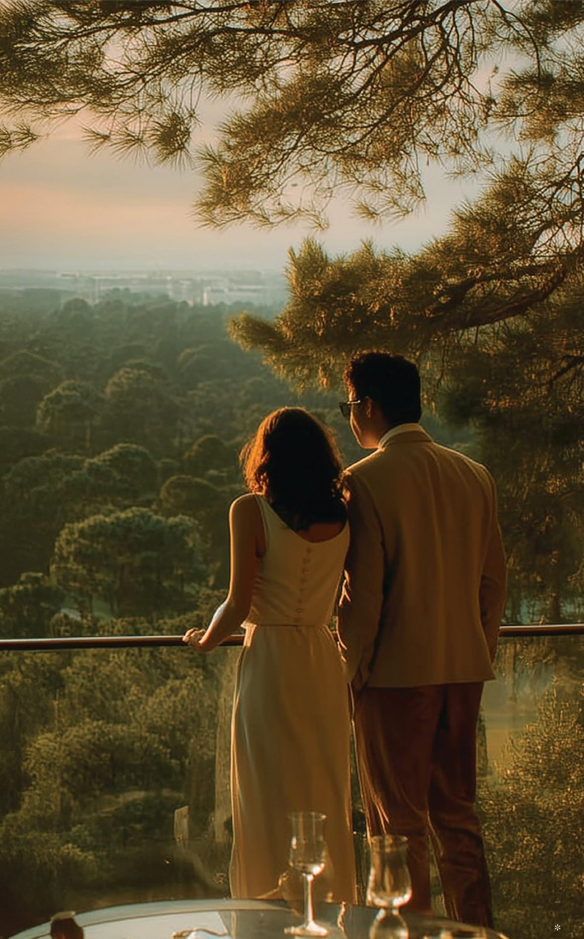 A couple on their private balcony at dusk, overlooking Jaypee Greens